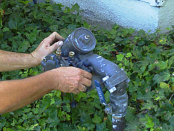 an irrigation repair specialist is doing a backflow repair